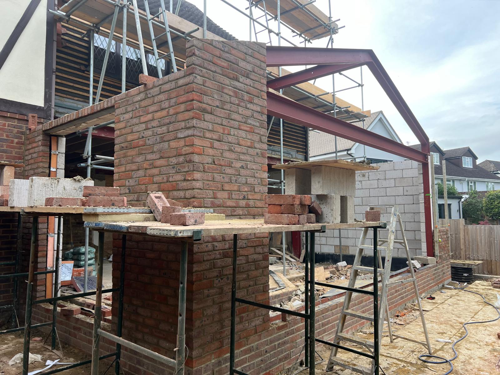 Brick chimney column built between steel beams with scaffolding