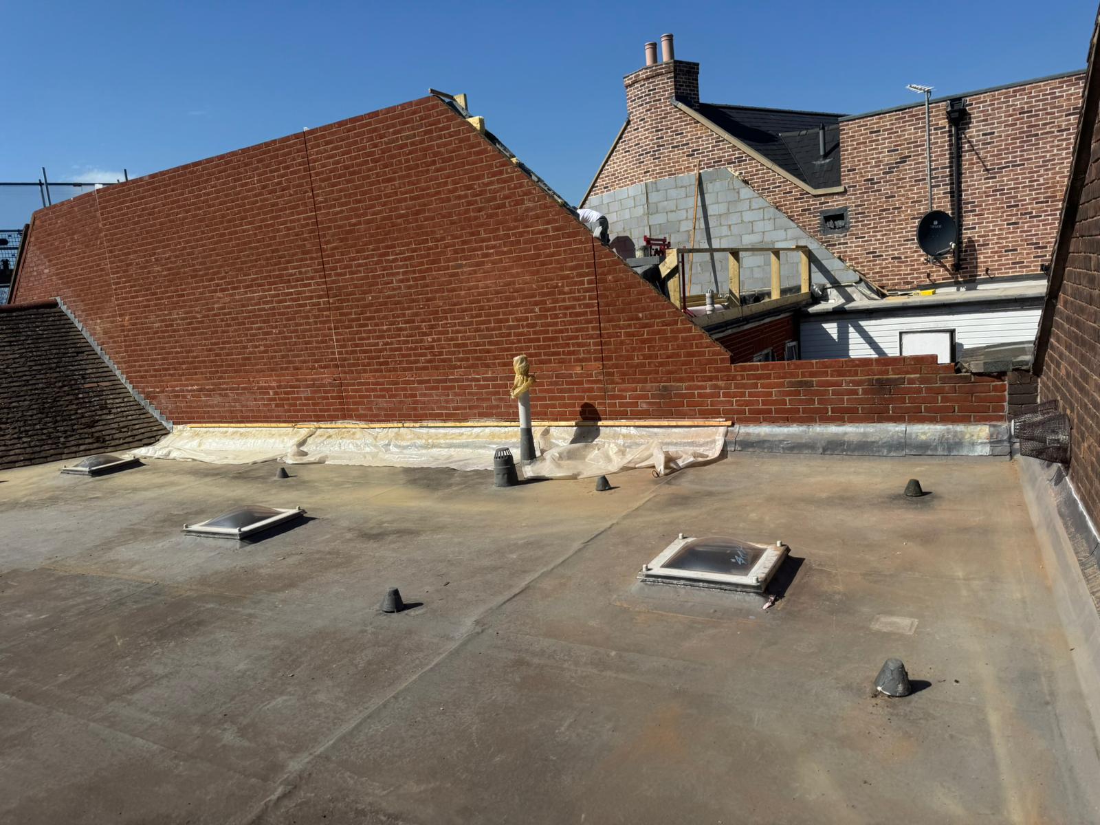 Repointing job on rooftop with red brick wall